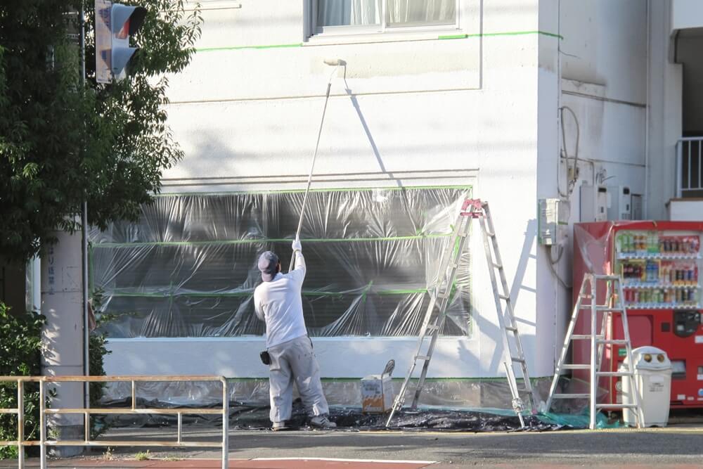 建物の外壁の塗装作業を行っている風景の写真